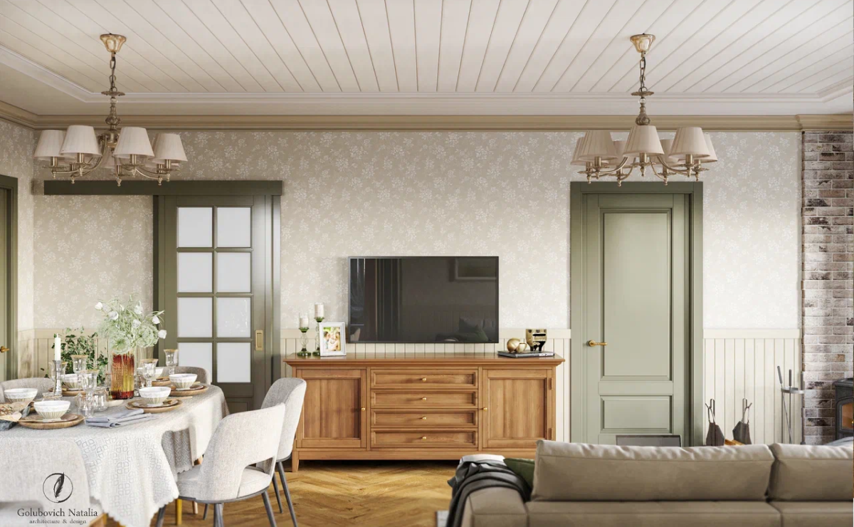 Приняв во внимание все пожелания заказчиков, для загородного дома выбрали теплые солнечные цвета, натуральные материалы и природные оттенки, поэтому даже стены пропитаны атмосферой спокойствия. В интерьере преобладают пастельные, спокойные цвета: охра, бежевый, травяной. Подобное цветовое решение позволяет ощутить себя в деревенском доме из детства, в котором когда-то гостил у бабушки. Поэтому закономерно, что в проекте преобладают природные мотивы. <br><br>

Так как брус, из которого возведен дом, не новый, его невозможно было отшлифовать, придав ему презентабельный внешний вид. Поэтому решили сымитировать дерево. Для этого стены в гостиной и спальне в некоторых местах зашили гипсокартоном, в других – вагонкой. Такой прием позволил оставить настроение и атмосферу загородного деревянного дома.<br>
На потолке также комбинация гипсокартона и вагонки. Стены оклеены обоями с мелким принтом. Подобный рисунок также придает интерьеру теплую атмосферу деревенского жилища. <br><br>

В наследство от прежних хозяев осталась печь. Ее также переделывали: полностью переложили, украсили плиткой-изразцами. Теперь в зоне кухни можно готовить настоящие блюда из печи, а в спальне – отдыхать и греться на уютной лежанке. <br><br>

Интересная деталь в этом дизайн-проекте – фреска с природной тематикой в изголовье кровати в спальне. Светло-зеленый, золотой, нежно-желтый… Цветочные мотивы фрески созвучны круглой оригинальной картине в прихожей, оттенку кухонного гарнитура, плитке на полу в кухне, паркету в кабинете. Все детали интерьера объединяют каждое помещение в единую концепцию. <br><br> 

Этот проект заслуживает внимания за выверенную игру деталей, максимальное заполнение пространства, индивидуальный подход к каждому элементу интерьера.  Для дизайнера нет незначительных мелочей. Все должно быть согласовано, играть единую мелодию. 
